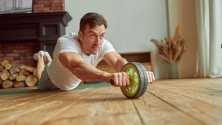 How to tone your stomach: Image shows person using ab wheel