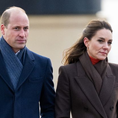 Prince William wears a navy overcoat and blue scarf while Kate Middleton wears a brown coat and matching scarf