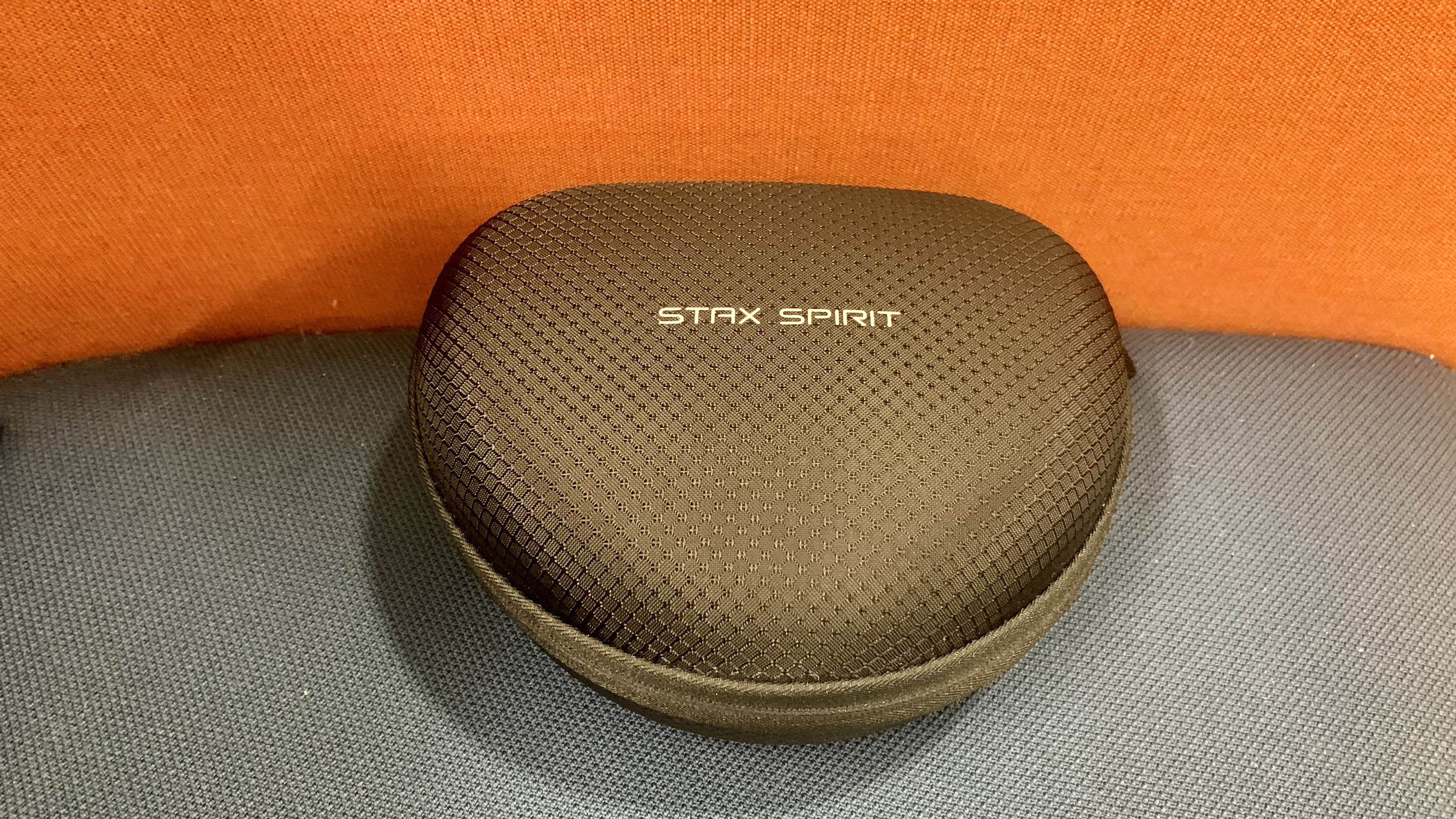 Edifier Stax Spirit S3 case, on orange and gray sofa