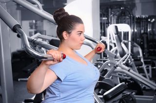 Overweight woman training at the gym.