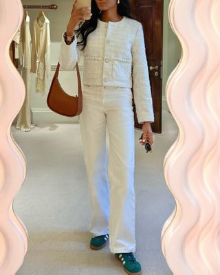 @symphonyofsilk wearing a bouclé jacket and white jeans