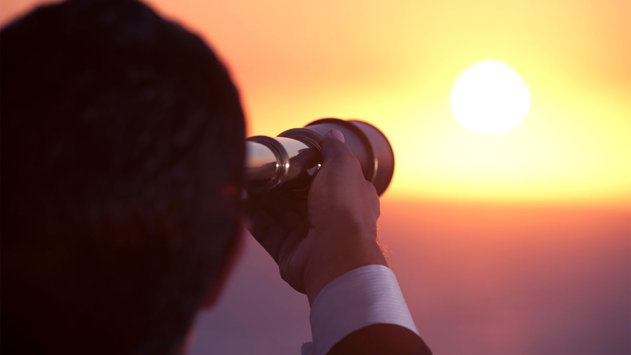 man looking at the sun using a solar equipped telescope