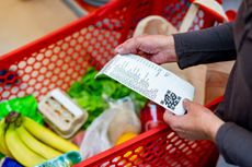 Close up of unrecognizable customer checking her receipt after purchasing groceries