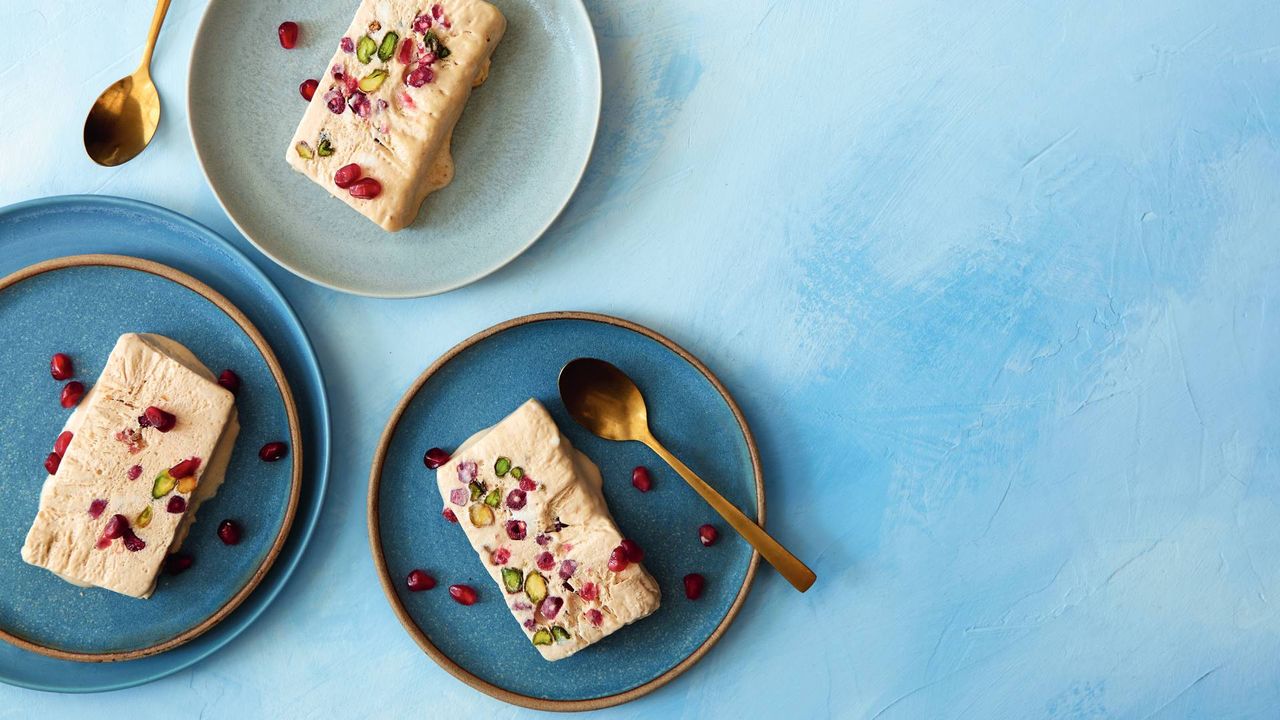 Three plates with a slice of parfait on each and some spoons