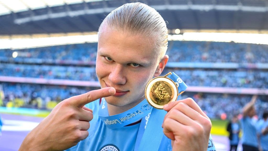 Erling Haaland points at his Premier League winner&#039;s medal.