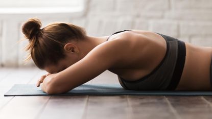 a woman lying on an exercise mat 