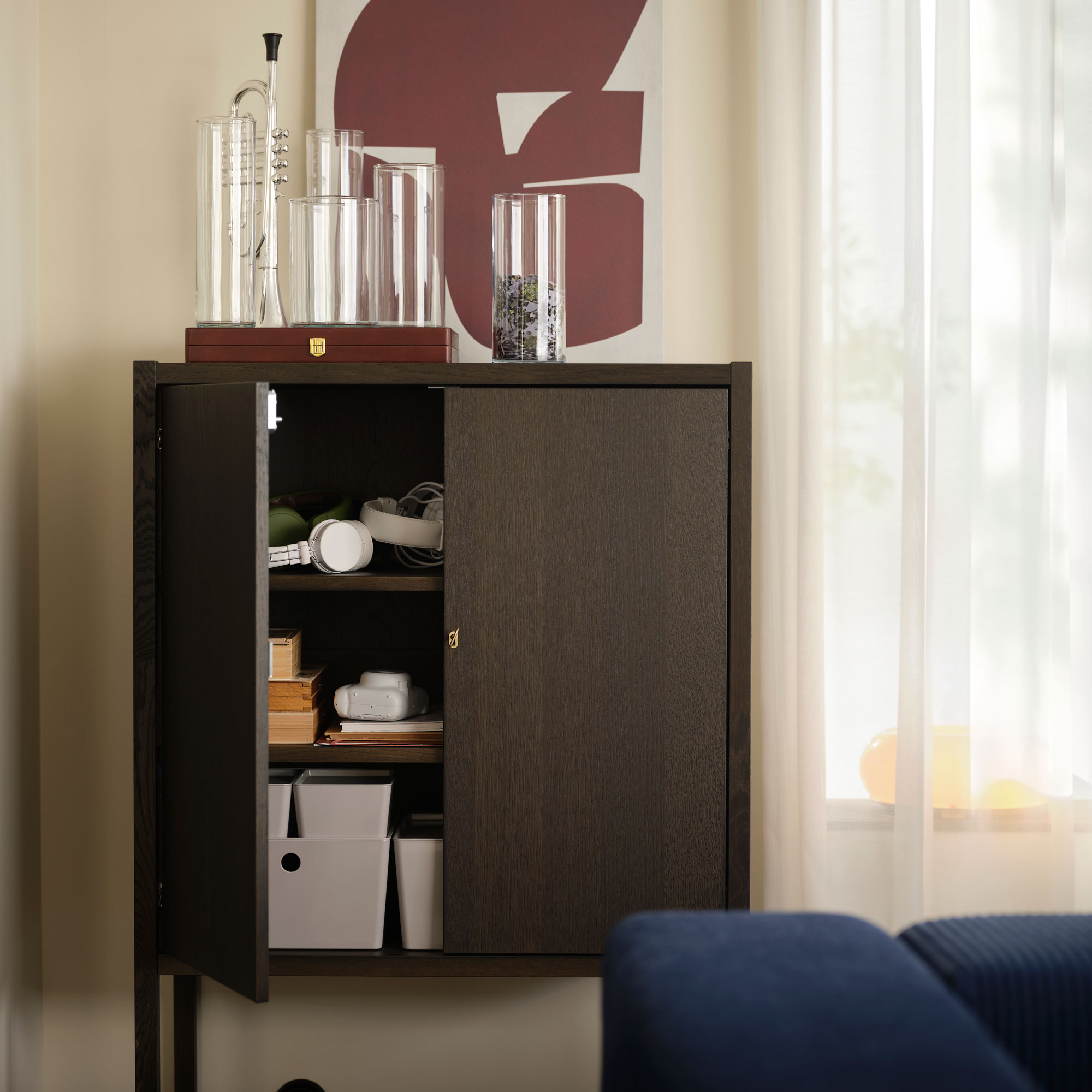 Wooden cabinet with boxes in and a tray on top