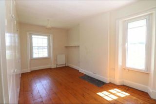 Before pic of bedroom with magnolia walls and wooden floorboards