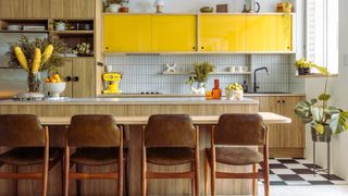 A kitchen with high gloss yellow cabinets