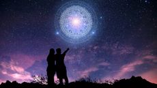 two people looking up at zodiac signs in the night sky