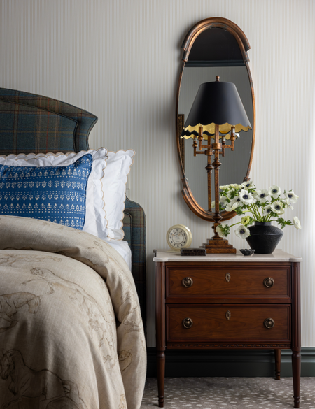 Equestrian-inspired bedroom featuring horse-motif bedding, aged brass accents, and wooden furniture