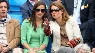 Pippa Middleton and Carole Middleton talk to each other during the Men's Singles second round match between Andy Murray of Great Britain and Nicolas Mahut of France at Queen's Club in 2013