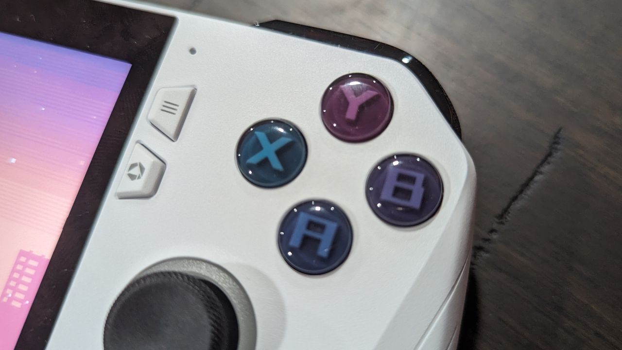 Asus ROG Ally Z1 on a brown table, highlighting the face buttons and analog stick on the right side.