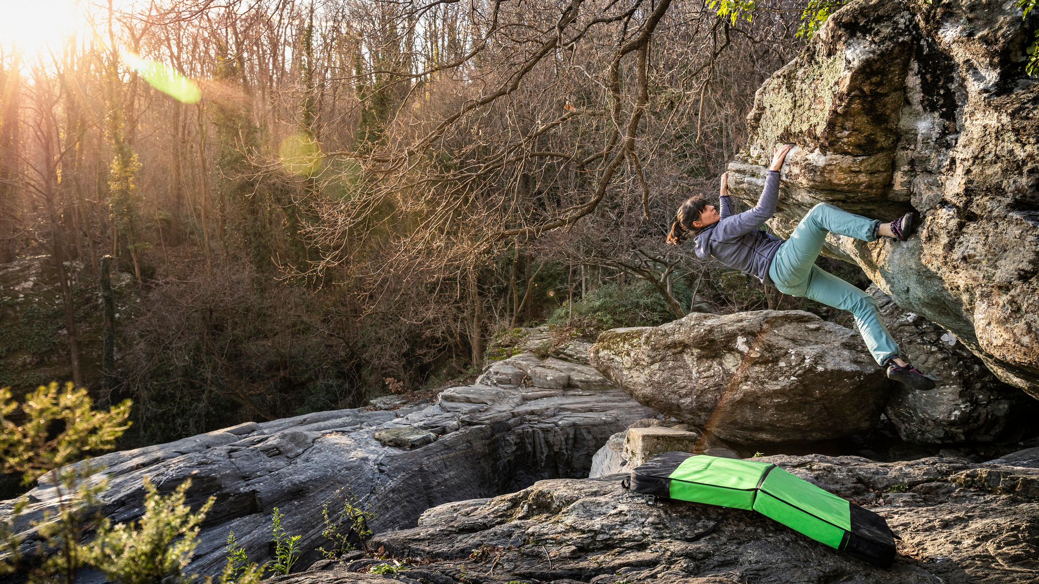 Climber bouldering with a crash mat