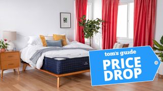 DreamCloud mattress in a bedroom with nightstand and red curtains