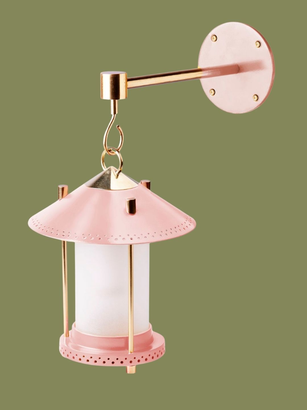 A blush pink small lantern hanging on a matching hook on a dark green background.