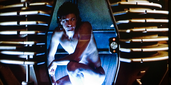 A naked, kneeling Jeff Golblum in The Fly