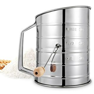 A silver hand crank flour sifter