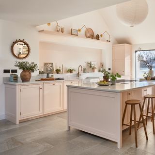 A kitchen with blush pink cabinets and island