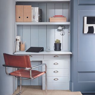 Home office with blue built-in desk and shelves