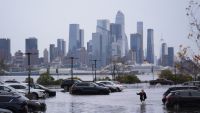 Cars submerged in flood water with New York City in the background