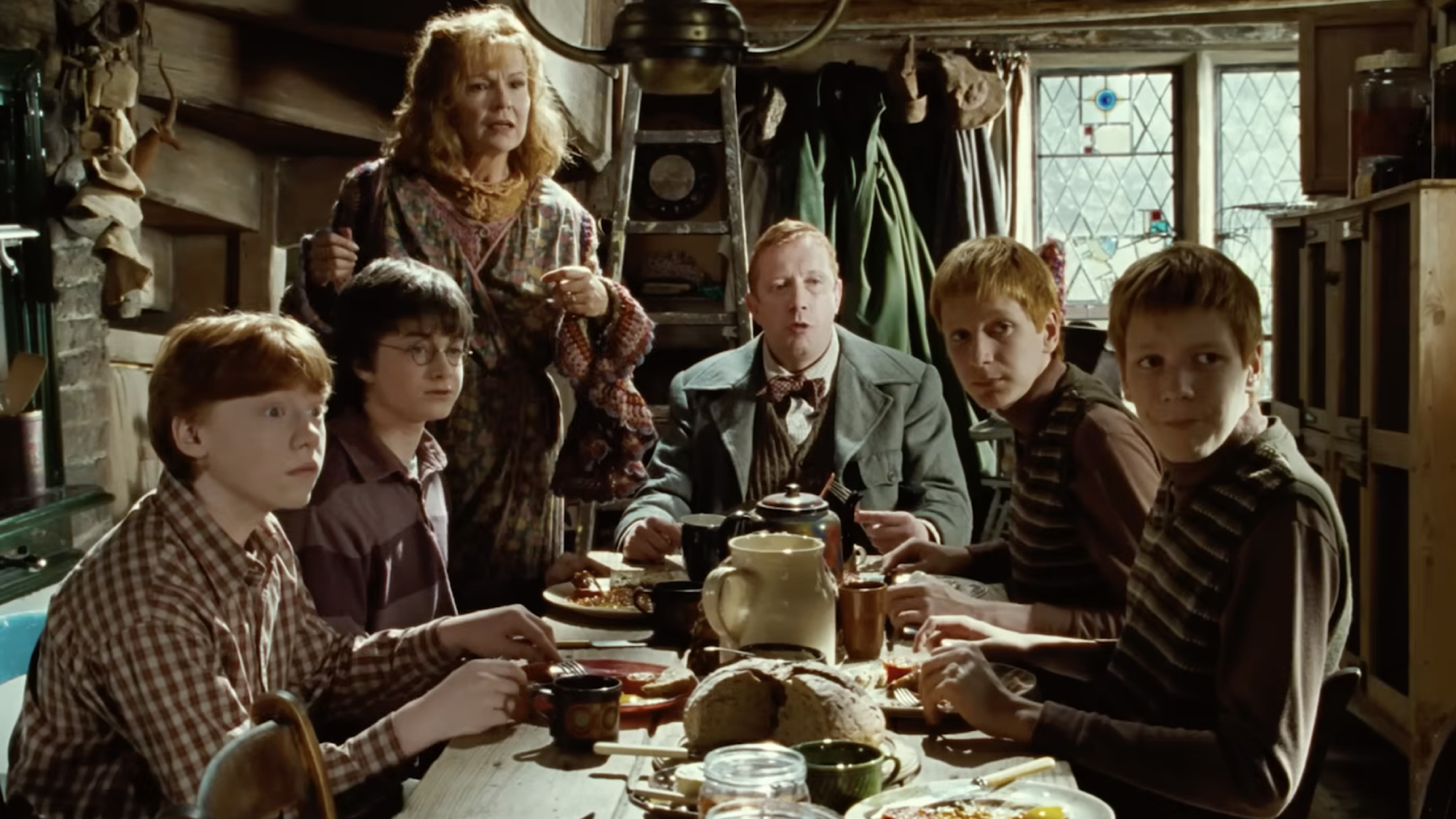 Ron, Harry, Molly, Arthur, Fred, and George at the Burrow eating breakfast in Harry Potter and the Chamber of Secrets.