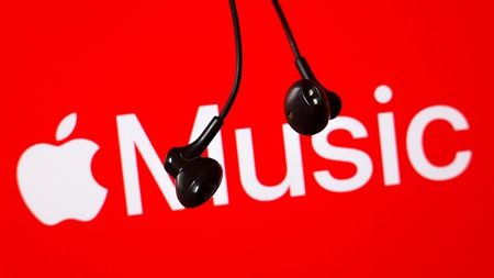 The Apple Music logo on a red background with wired headphones hanging down