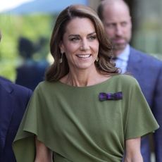 Kate Middleton wears an olive green dress with brown heels and a brown DeMellier bag at Wimbledon.
