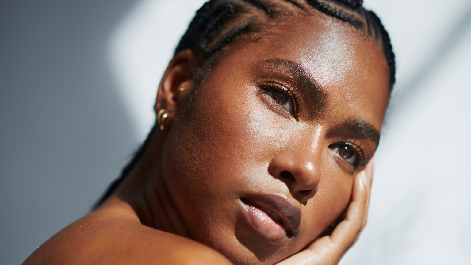 black woman with glowing skin against a sunny backdrop