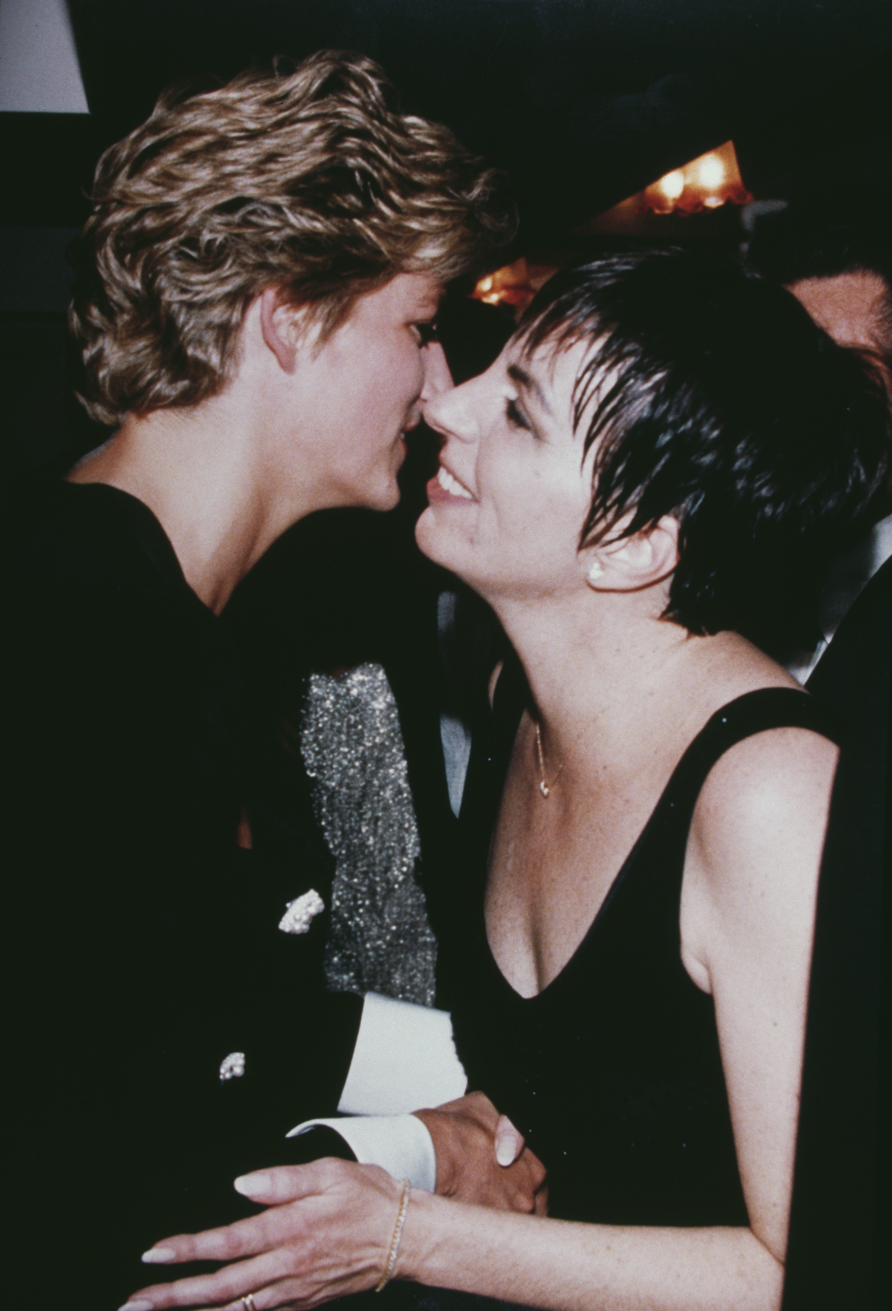 Princess Diana wearing black kissing Liza Minnelli on the cheek