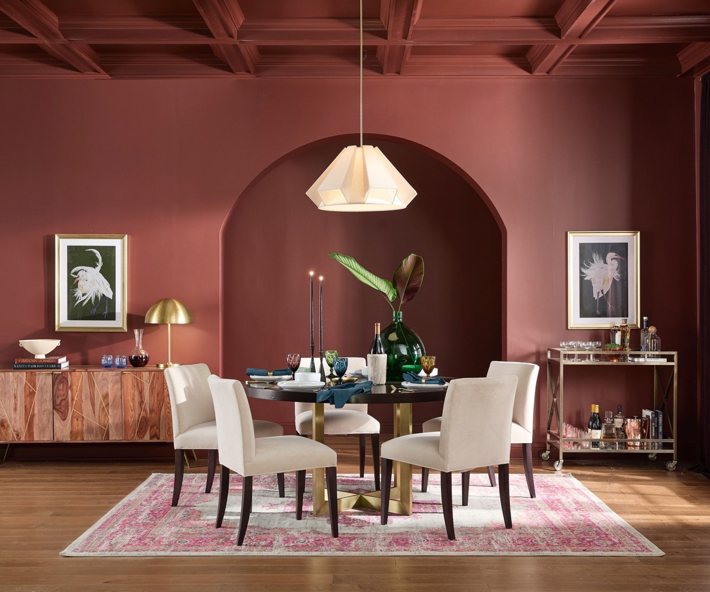 Mahogany red painted dining room with arched nook, wood and gold table with boucle chairs, console and bar cart