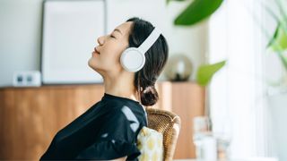 Woman sitting back in chair wearing headphones