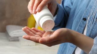 Woman pouring baby powder in hand