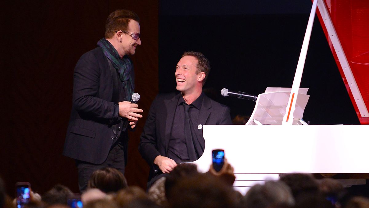 Bono (L) and Chris Martin perform on stage at Sotheby&#039;s during the 2013 (RED) Auction Celebrating Masterworks Of Design and Innovation on November 23, 2013 in New York City