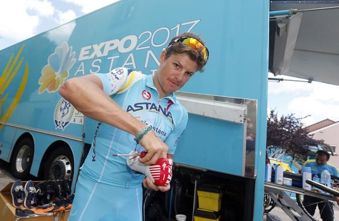 Jakob Fuglsang checks hi show on the start line of stage 11