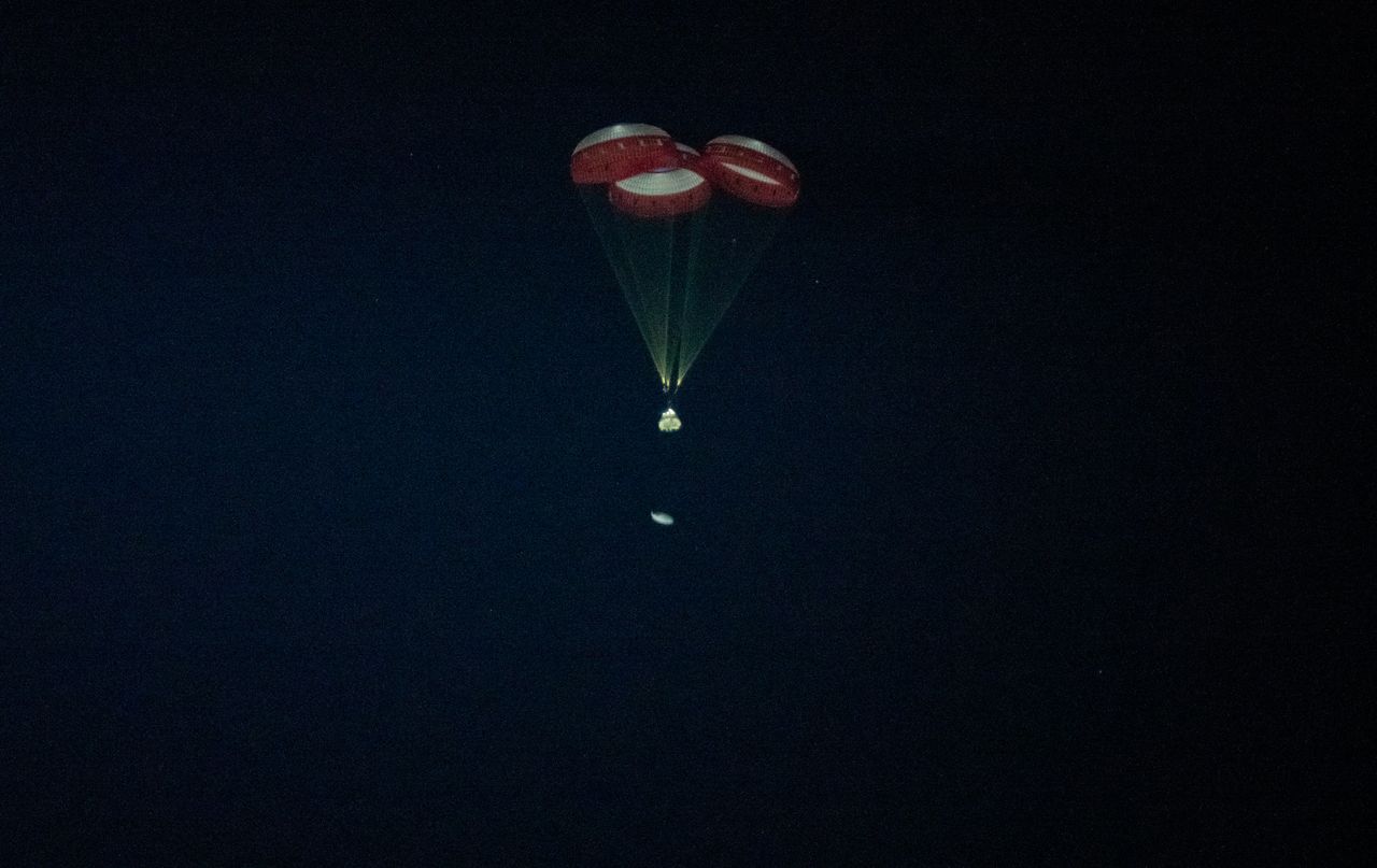 Boeing's first Starliner spacecraft jettisons its heat shield as it parachutes back to Earth for a successful landing at White Sands Space Harbor in New Mexico on Dec. 22, 2019.