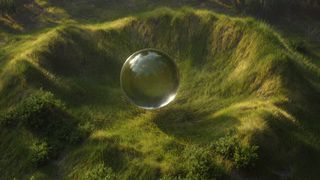Image of a transparent ball sat in a lush green valley
