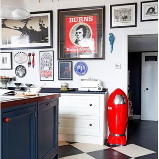 white Shaker kitchen, black and white check floor tiles, red rocket shaped bin