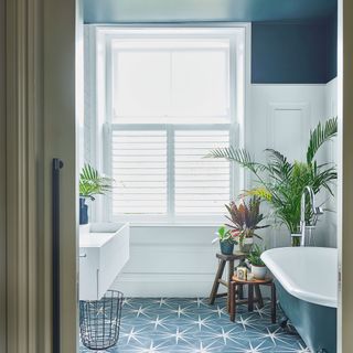 en suite bathroom with bathtub and printed tiled flooring