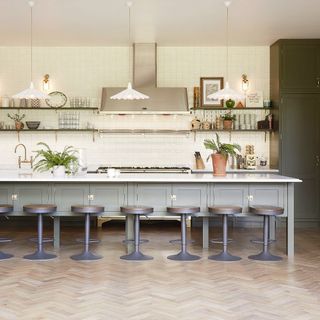 Green classic kitchen with large kitchen island and white wall tiles