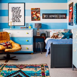 Blue and white striped boys bedroom with artwork and Aztec rug