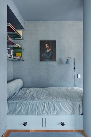 A monochromatic blue bedroom with storage