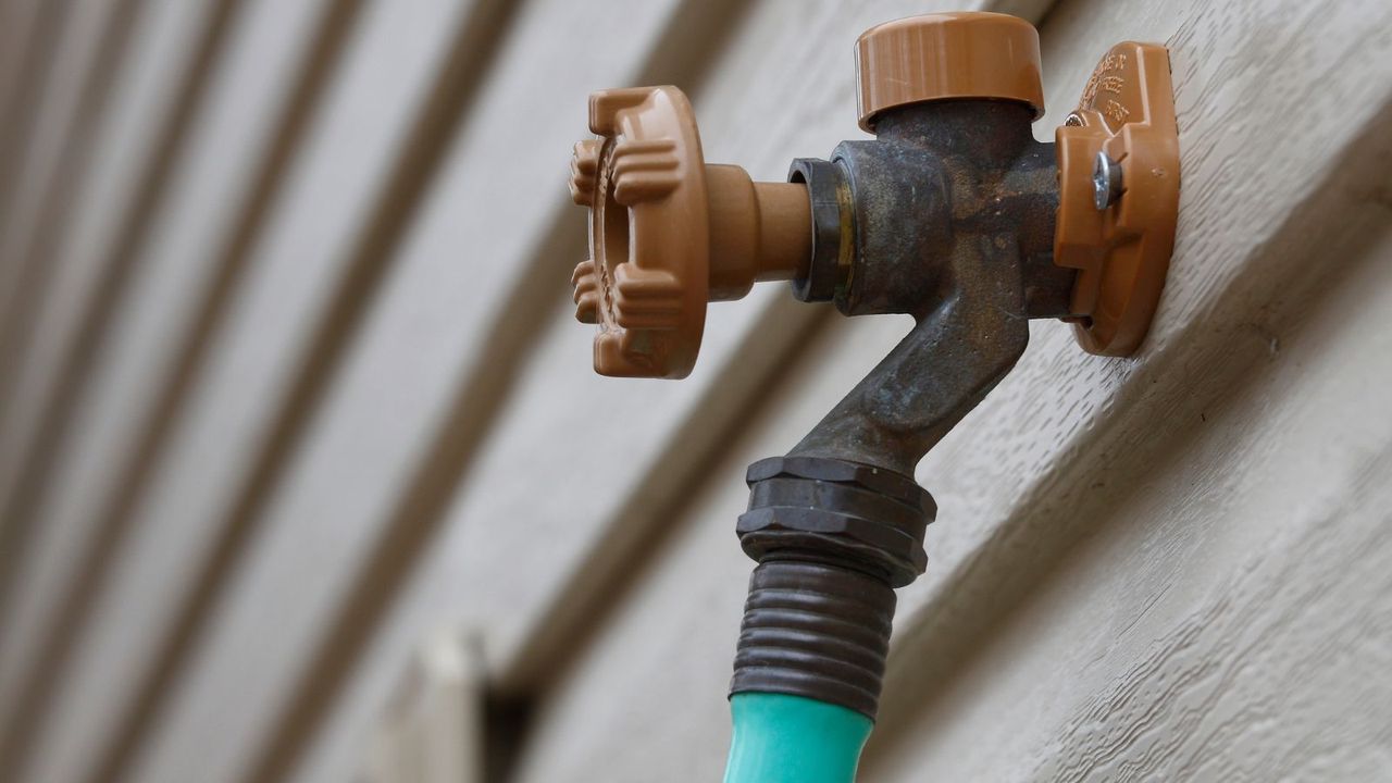 A closeup of a spigot and hose 