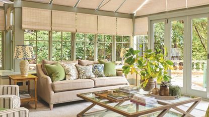 Sunroom with light green walls, rattan shades and pale beige sofa