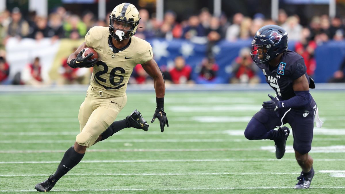 Army Black Knights player Kanye Udoh pursued by Navy Midshipmen&#039;s Mbiti Williams Jr in the Army vs Navy football match in 2023