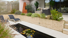 a paved patio with a small rill, two sun loungers and a heater