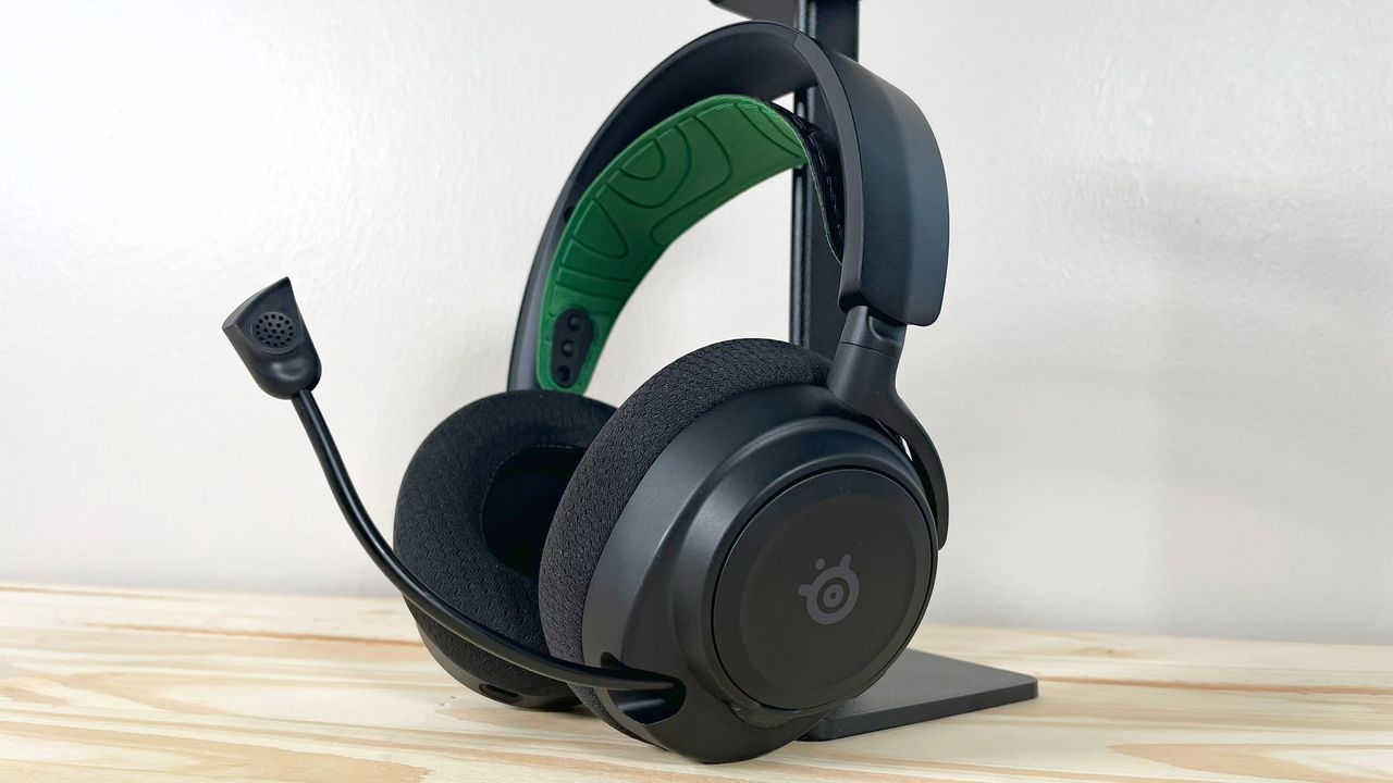 The SteelSeries Arctis Nova 7X with mic extended on a wood table