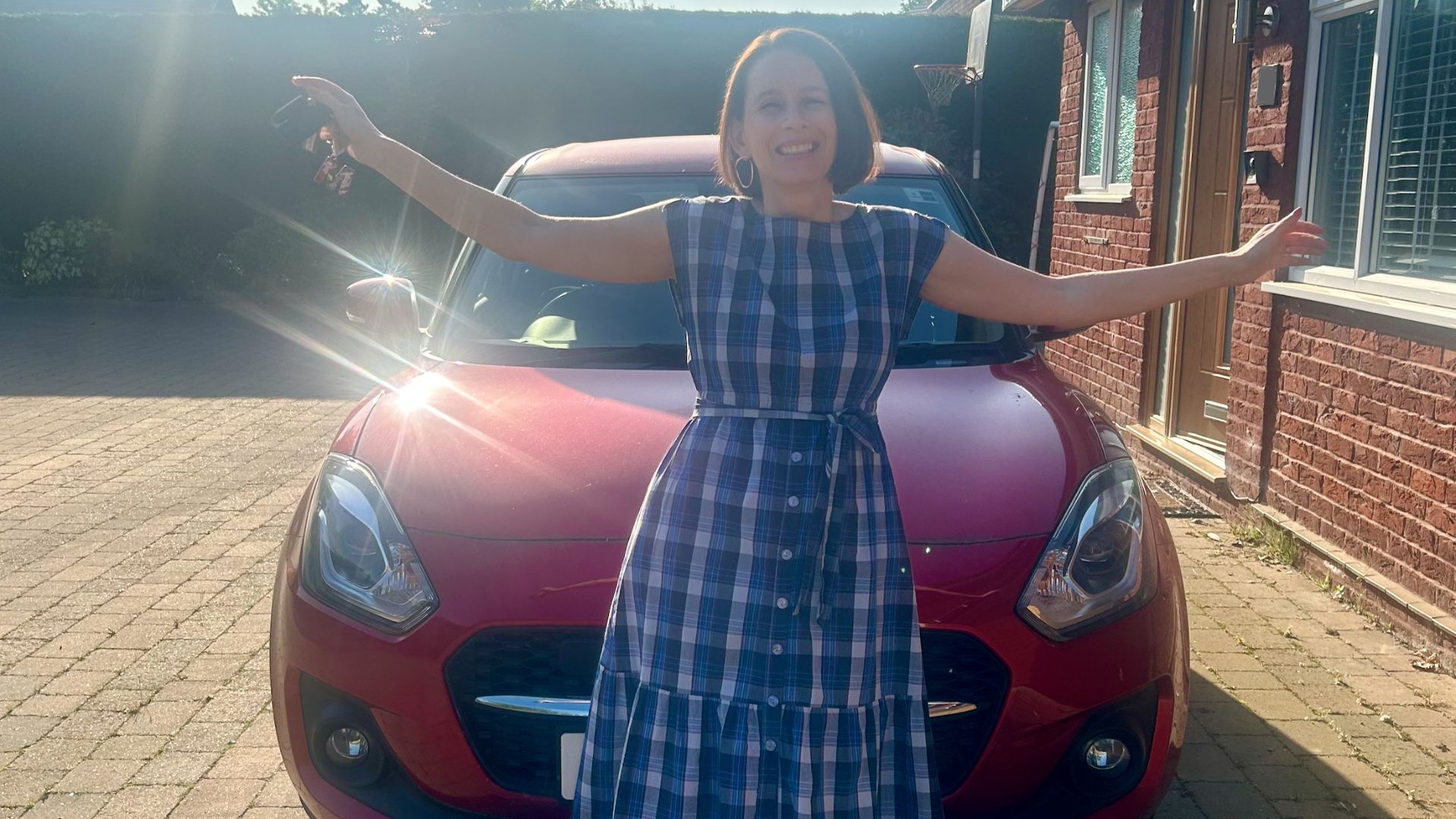 Michelle Rowley with her car, smiling