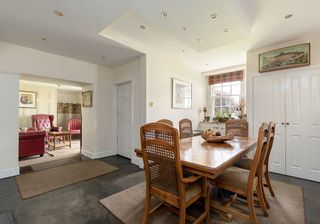 dining area with white wall and concrete flooring and dining table with chairs