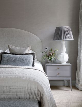 Grey bedroom with bedside table and lamp